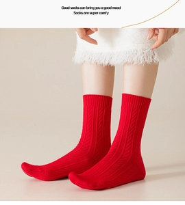 Detail of red cable-knit festive socks made of warm cotton blend for winter season