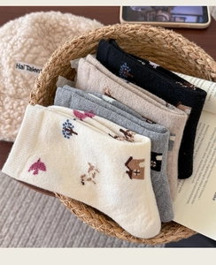 Detail of four pairs of warm wool socks with Nordic style embroidery in a basket