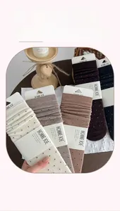 Detailed view of knitted wool crew socks with polka dots in beige and brown tones