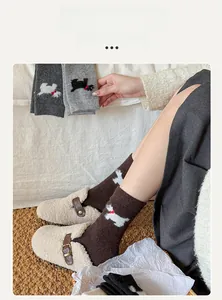Gros plan de chaussettes en laine marron avec motif chien et pantoufles douillettes