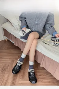 Detail of warm striped crew socks paired with black patent lace-up loafers with plush lining