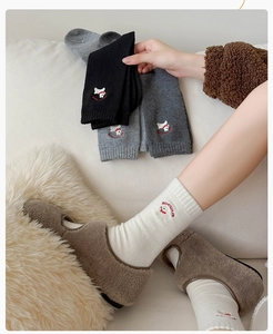 Close-up of cute puppy embroidery and ribbed cuffs on wool socks in various colors