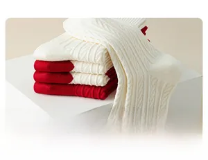 Detail of red and white striped knit socks with cable texture on display stand
