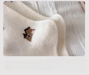Macro detail of reinforced heel on soft wool knit socks with small house embroidery