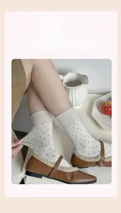 Detail showing the high elasticity of white polka dot wool blend crew socks for women