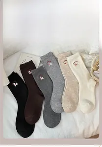 Close-up of wool-blend mid-calf socks with cute puppy embroidery in six neutral colors