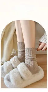 Detail of high-elasticity ribbed wool socks with cozy plush slippers on wooden floor