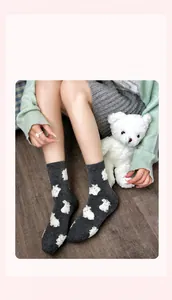 Detail of dark grey knit socks with white fuzzy bunny patterns for winter warmth