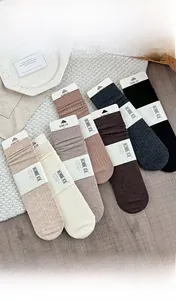 Vertical rib knit wool mid-calf socks in six neutral earth tones with brand packaging