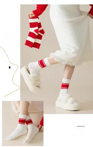 Detail of white cotton mid-calf socks with red stripes and ribbed knit texture