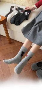 Detail von warmen Strick-Wollsocken mit süßen Cartoon-Katzenmotiven in verschiedenen Farben