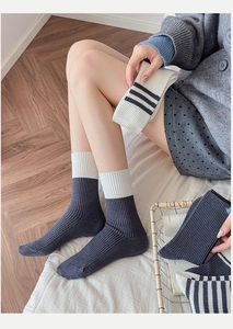 Detailed texture of ribbed knit mid-calf socks in grey and striped patterns