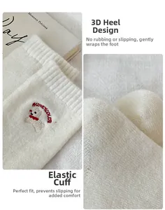 Detail of white knit crew socks featuring cute bear embroidery and ribbed elastic cuffs