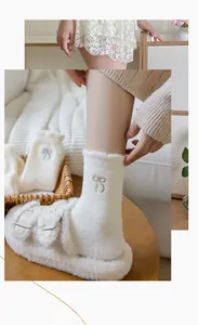 Detailed view of warm white coral fleece socks with elegant bow embroidery and lace trim