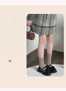 Detail of black platform Mary Jane shoes with double straps and brown polka dot socks