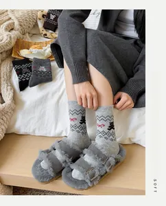 Gemütliche Kombi aus grauen Bären-Jacquard-Socken und Plüschhausschuhen in Innenräumen