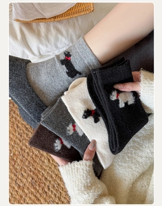 Gros plan détaillé de chaussettes en laine avec broderie chien Scottie et poignets côtelés
