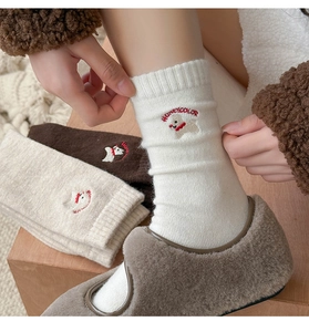 Detail of wool blend socks with cute puppy embroidery and Honeycolor text in beige tones