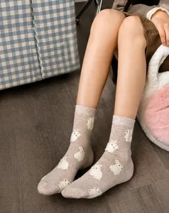 Close-up of soft khaki knit socks with cute white flocked rabbit patterns and texture