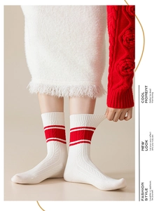 Detailed knit texture of white crew socks with classic red stripes for a festive winter look
