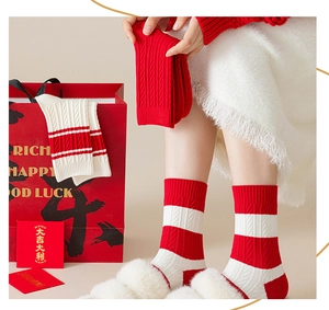 Detail of red and white striped thick knit mid-tube socks with festive gift packaging
