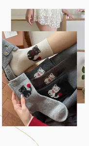 Detailaufnahme süßer Katzen-Jacquardmuster auf dicken, warmen Wollsocken in mehreren Farben