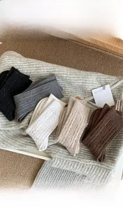 Detail of five winter knitted crew socks in various colors with textured cable knit patterns