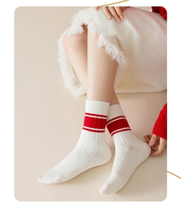 Detail of white cotton crew socks with red stripes and ribbed knit texture