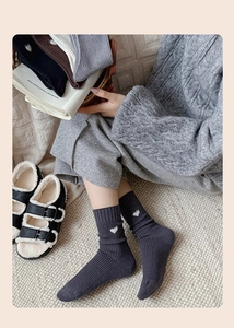 Detailed knit texture and white heart embroidery on ribbed crew socks in various colors