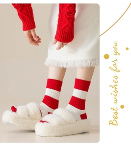 Detail of red and white striped cable knit socks with plush white faux fur slide slippers