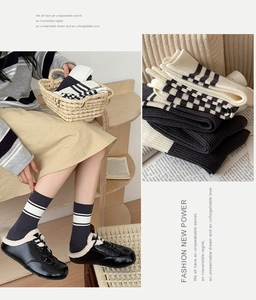 Detail of knitted mid-tube striped socks in grey and beige for autumn and winter