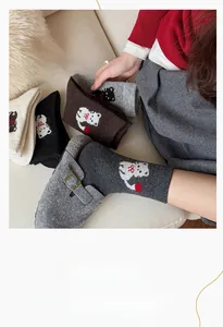 Nahaufnahme gemütlicher Strick-Crew-Socken mit süßer weißer Katzenstickerei in Farben