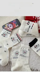 Detail of white cotton crew socks with cute cartoon puppy patterns and ribbed cuffs