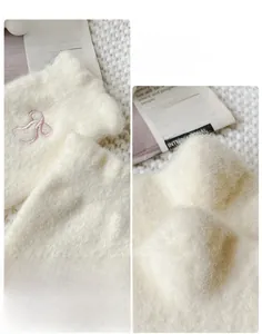 Detailed close-up of white plush thermal socks with delicate pink embroidered bow accents