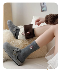 Detail of grey felt clogs with buckle paired with cute puppy embroidery wool socks