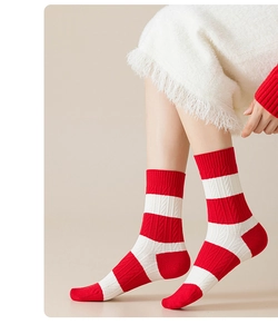 Macro shot of red and white striped cable knit mid-calf socks for women