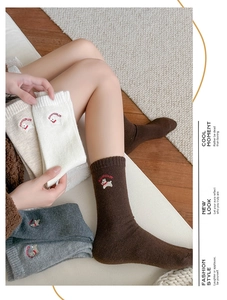 Detail of wool socks showing cute puppy embroidery and Honeycolor text on ribbed cuff