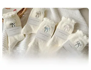 Detail view of five pairs of warm white wool socks with colorful embroidered bows