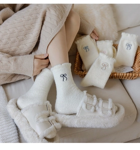 Detailed close-up of fluffy winter socks featuring elegant bow embroidery and soft texture