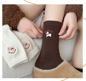 Detailed embroidery of a white puppy and brand text on warm wool mid-calf socks