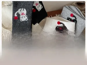 Nahaufnahme süßer Cartoon-Katzen-Socken mit Pompons und warmer Baumwollstruktur