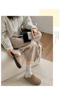 Brown suede clog slide sandals with metal buckle worn over cozy grey knit socks