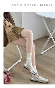 Detail showing off-white ribbed wool socks paired with silver Mary Jane shoes