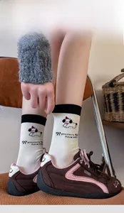 Detail of white cotton crew socks with cartoon puppy embroidery and ribbed cuffs