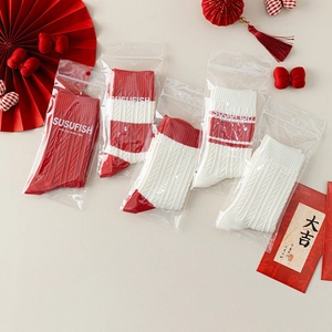 Five pairs of red and white knitted festive socks in independent zipper bag packaging