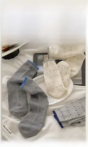 Detail of wool socks with floral dot patterns and elegant wavy lettuce edges