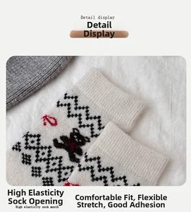 Detailansicht der Wollsocken mit Bärenstickerei und Wellenmuster auf weißem Strickgewebe