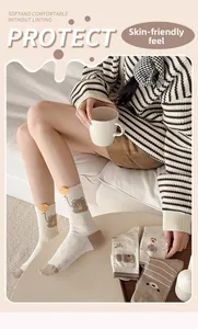 Detailaufnahme süßer Bären-Beflockung auf gestrickten beigen Baumwollsocken für Damen