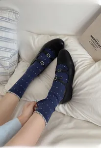 Close-up of wool socks with floral patterns and ruffled edges in casual home setting