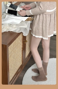 Close-up of knit texture on striped wool crew socks in warm coffee and cream white